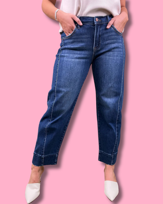 Person wearing blue jeans on a pink background