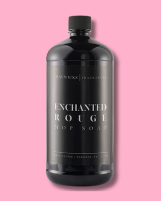 Black soap bottle labeled 'Enchanted Rouge' on a pink background