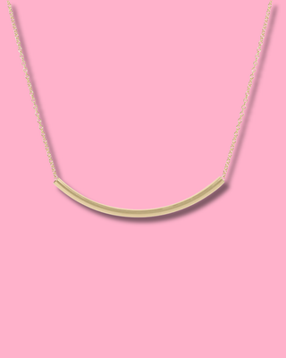 Gold necklace on a pink background