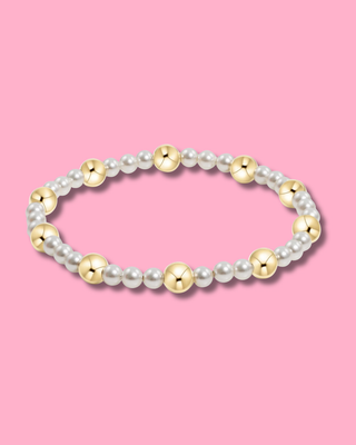 Pearl and gold bead bracelet on a pink background