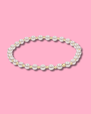 Pearl necklace with gold accents on a pink background