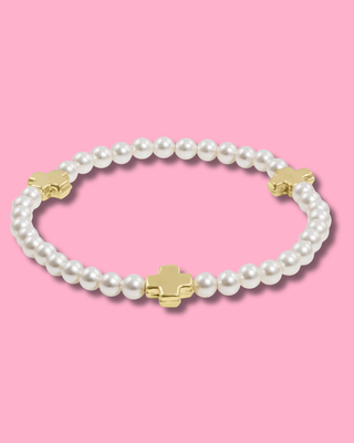Pearl bracelet with gold accents on a pink background