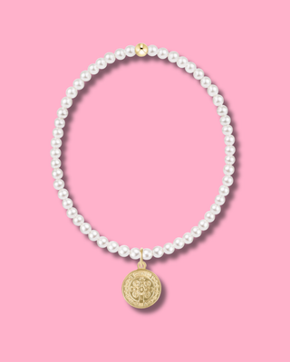 Pearl necklace with a gold pendant on a pink background
