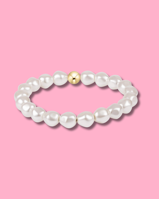 Pearl bracelet with a gold bead on a pink background