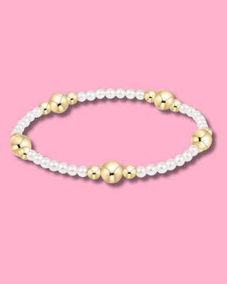 Bracelet with gold and pearl beads on a pink background