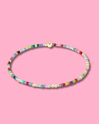 Colorful beaded necklace on a pink background