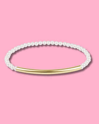 Pearl bracelet with gold bar on a pink background