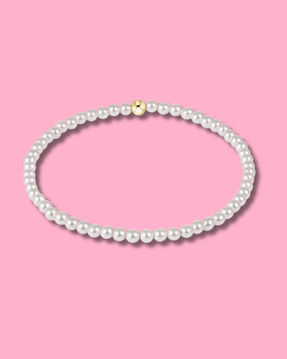 Pearl necklace with a gold clasp on a pink background