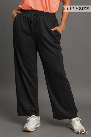 Person wearing black plus size pants on a gray background
