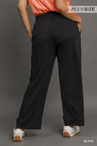 Person wearing black plus-size pants on a gray background