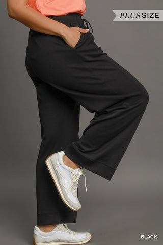Person wearing black plus-size pants with a gray background