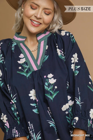 Woman wearing a navy blue floral blouse with a beige background