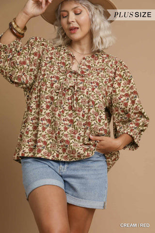 Woman wearing a floral blouse and denim shorts on a beige background