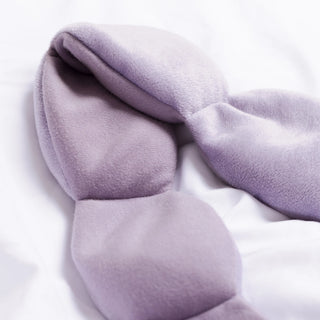 Folded light purple weighted eye mask on a white background