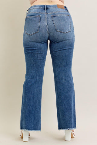 Blue jeans worn by a person on a beige background