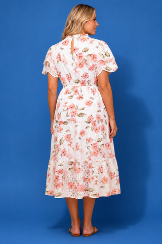 Woman wearing a floral dress against a blue background