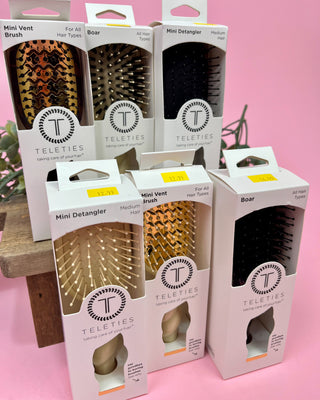 Packaging of Teleties hairbrushes on a pink background