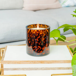 Candle with tortoiseshell pattern on a wooden tray in a living room setting