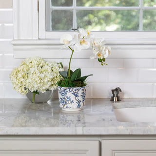 Floral arrangements on a kitchen counter with a window in the background