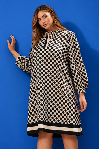 Woman wearing a polka dot dress against a blue background