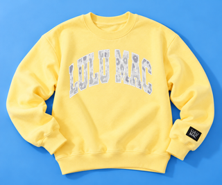 Butter Yellow & White Camo Patch Sweatshirt with cozy fleece lining and oversized camo patch lettering.