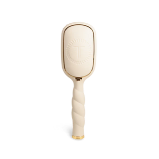 Beige paddle hairbrush with gold accents on a white background