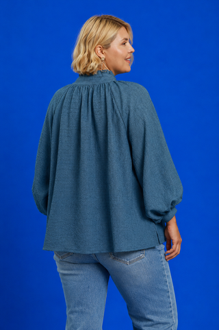 Blue Button Up Tiered Denim Top in soft 100% Tencel with a button front, chest pocket, tiered peplum hem, and relaxed fit.