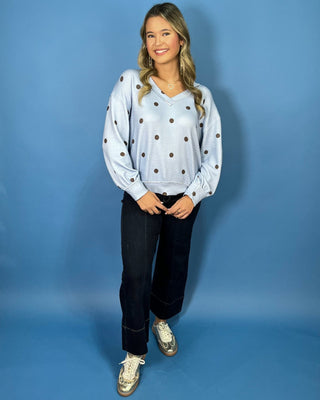 Light blue textured polka dot V-neck top with contrasting brown dots, relaxed drop shoulders, long sleeves