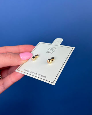 eNewton Small Gold Cross Stud Earrings in classic gold featuring petite gold cross studs with polished gold ball accents and secure post backs displayed on an eNewton jewelry card.