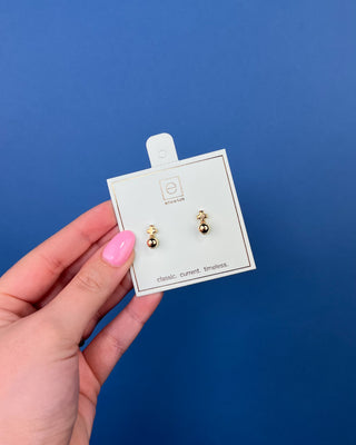 eNewton Small Gold Cross Stud Earrings in classic gold featuring petite gold cross studs with polished gold ball accents and secure post backs displayed on an eNewton jewelry card.