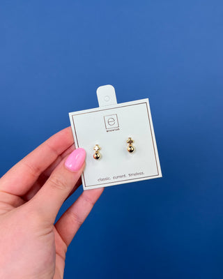 eNewton Small Gold Cross Stud Earrings in classic gold featuring petite gold cross studs with polished gold ball accents and secure post backs displayed on an eNewton jewelry card.