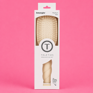 Packaging of a hair detangler brush with 'Teleties' branding on a pink background
