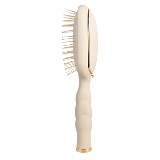 Beige hairbrush with gold accents on a white background