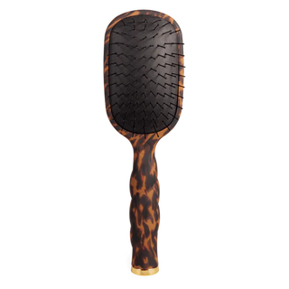 Tortoiseshell paddle hair brush on a white background