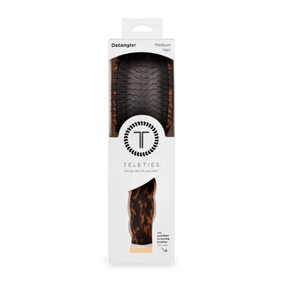 Hair detangler with packaging labeled 'Teleties' on a white background