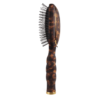 Tortoiseshell hairbrush with gold accents on a white background