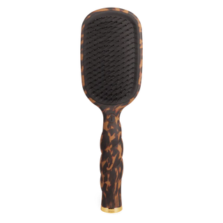 Paddle hairbrush with tortoiseshell handle on a white background