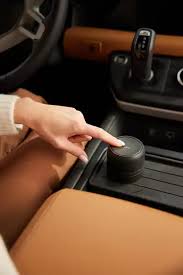 Person adjusting a car cup holder cover in a vehicle.