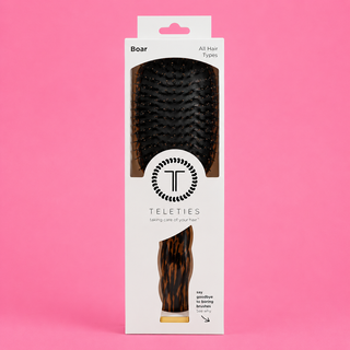 Hairbrush packaging with Teleties logo on a pink background