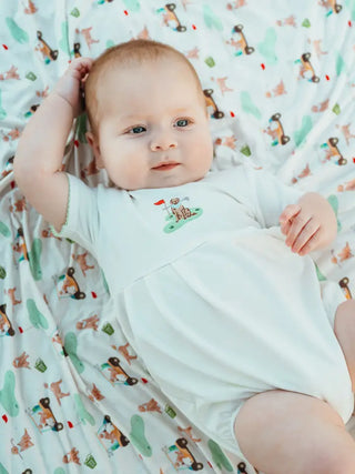 Baby lying on a crib with a patterned sheet
