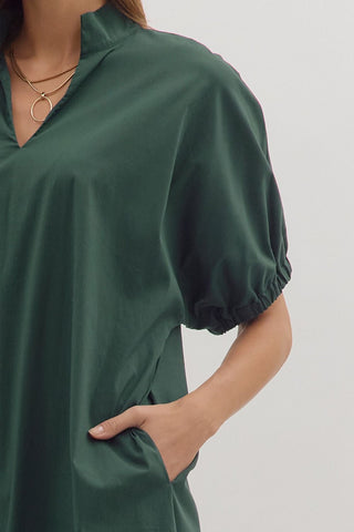 Green dress worn by a person on a plain background