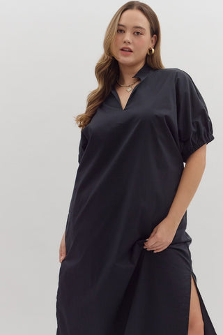 Woman wearing a black dress with a slit on a white background