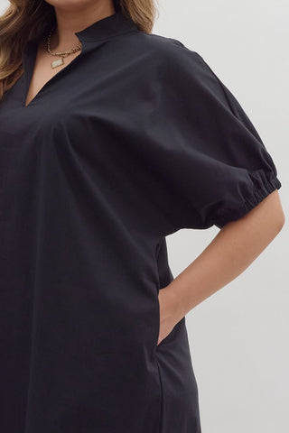 Black dress with short sleeves on a plain background