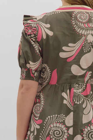 Person wearing a dress with a floral pattern on a plain background