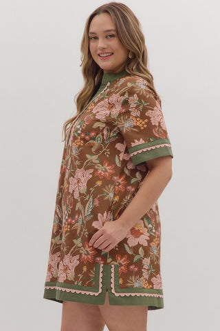Woman wearing a floral dress with a brown and green color scheme on a white background