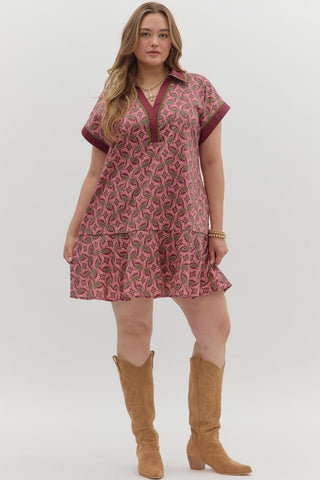 Woman wearing a patterned dress and brown boots on a white background