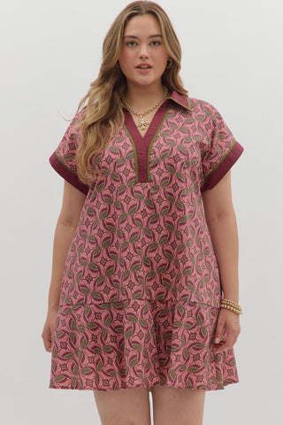 Woman wearing a pink patterned dress with a white background