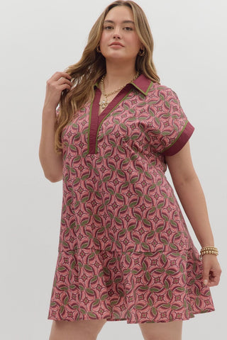 Woman wearing a pink patterned dress against a white background