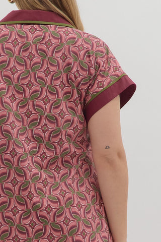 Close-up of a pink patterned garment with green accents on a plain background