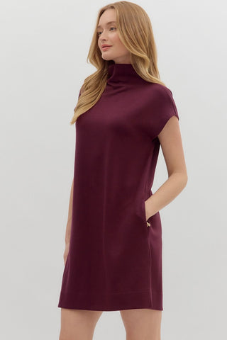 Woman wearing a burgundy dress against a white background
